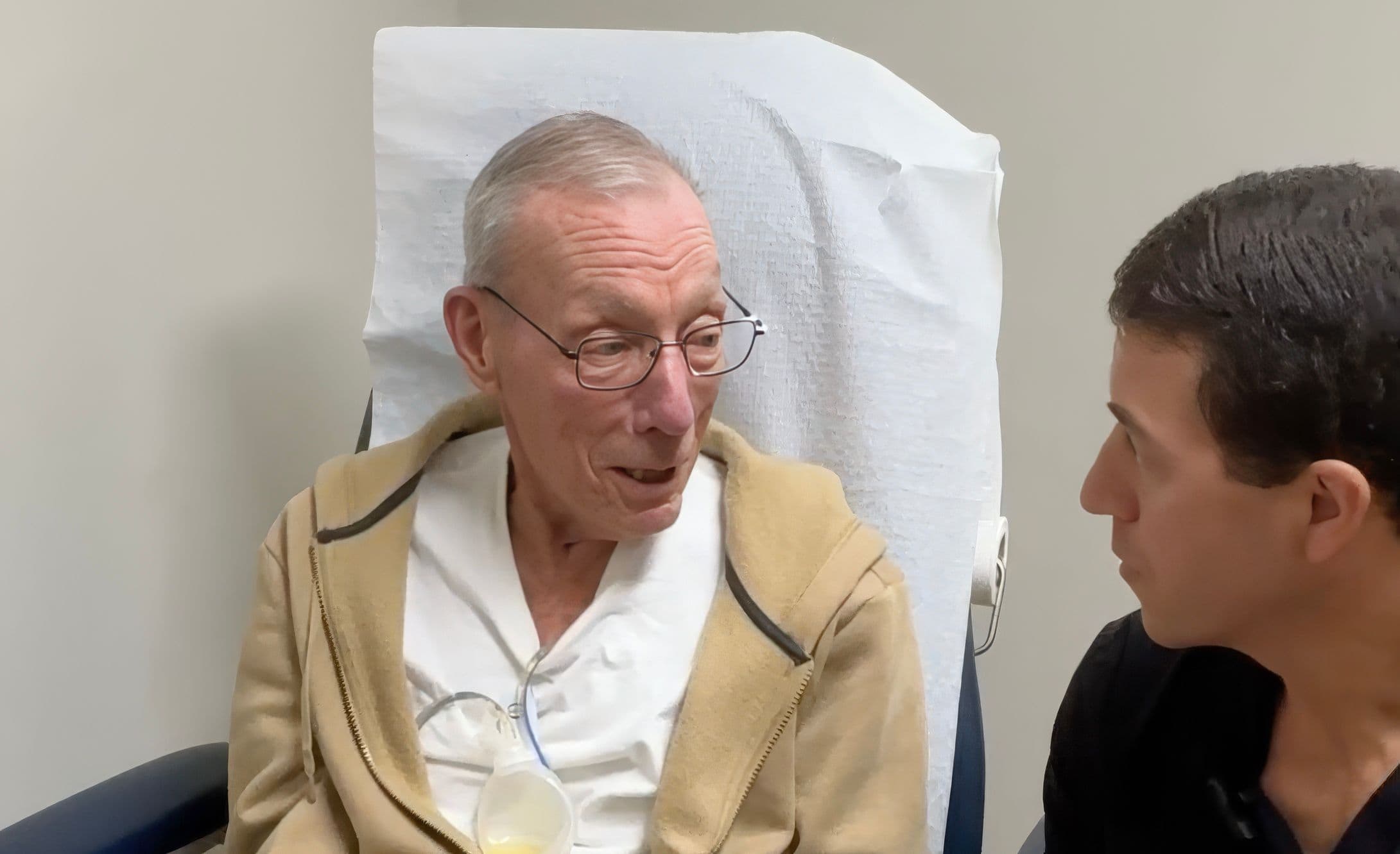 Patient discussing post-surgery experience with doctor in a clinical setting, highlighting quick recovery and satisfaction with InvisiFoot™ procedure.