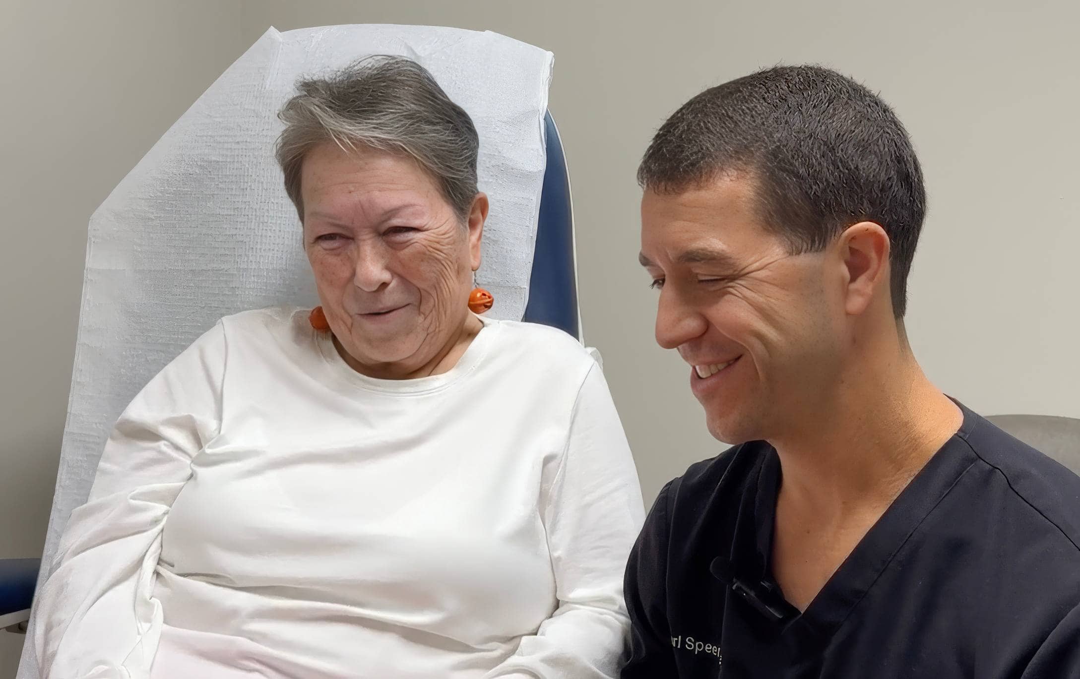Patient and Dr. Speer smiling together in a clinical setting, highlighting positive patient experience and care at Emerald Coast Foot and Ankle Center.